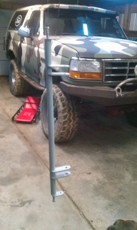 1995 Ford Bronco - Camouflaged 1995 Ford Bronco in a garage with a metal pole obscuring the front view.