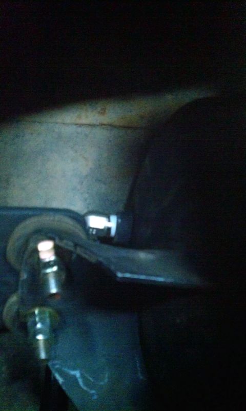 1995 Ford Bronco - Detail of a vehicle suspension part, possibly a shock hoop mount, with visible hardware.