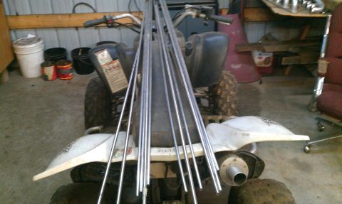 1995 Ford Bronco - An ATV is loaded with long metal rods, ready for transport or a project.