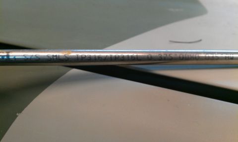 1995 Ford Bronco - A metal tube with etched text is shown, possibly a vehicle part.
