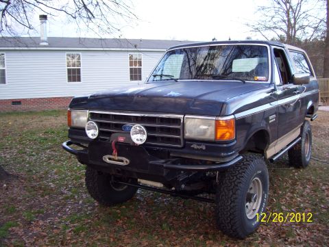 1990 Ford Bronco - This 1990 Ford Bronco features a custom front bumper with a winch and auxiliary lights, and appears to be lifted.