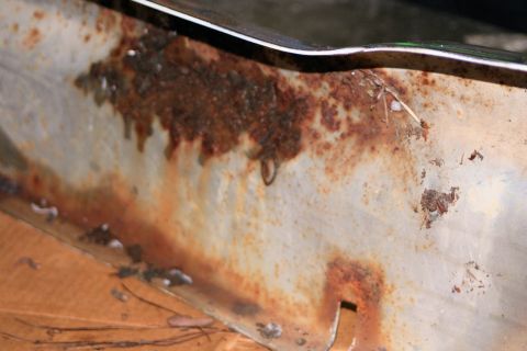 1976 Ford Ranchero - This image shows a heavily corroded metal panel, likely part of a vehicle's exterior, with visible rust and damage.