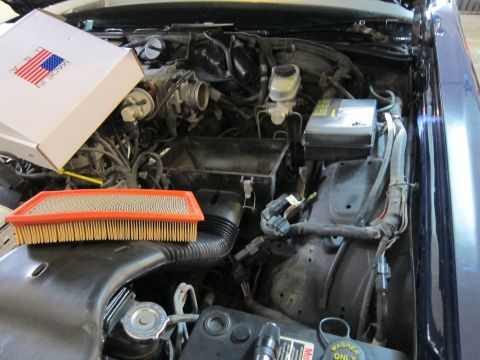 1991 Ford LTD Crown Victoria - Engine bay of a Ford Crown Victoria with a new air filter and its packaging visible.