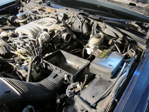 1991 Ford LTD Crown Victoria - Engine bay of a vehicle, with the air intake box removed for access to engine components.