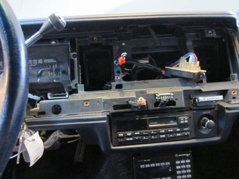 1991 Ford LTD Crown Victoria - The dashboard of a car with the center console disassembled, revealing wiring and internal components.