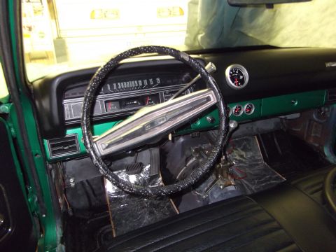1971 Ford Ranchero - Interior view of a green vehicle, showing the dashboard, steering wheel, and aftermarket gauges.