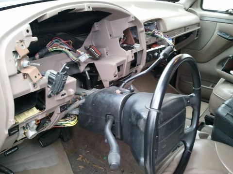 1994 Ford Bronco - Interior view of a 1994 Ford Bronco with the dashboard removed, exposing wiring and steering components.