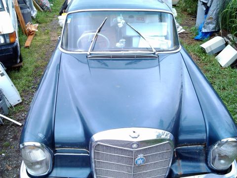 1969 Lincoln Continental - A blue sedan is parked outdoors with its front end visible, showing the grille and windshield.