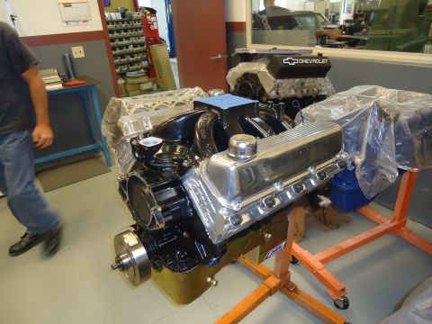 1988 Ford Mustang - Workshop scene with two Chevrolet V8 engines on stands, one a black valve cover with the Chevrolet logo.