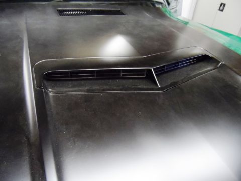 1971 Ford Ranchero - The hood of a vehicle features a raised scoop with horizontal vents, showing dust and wear.