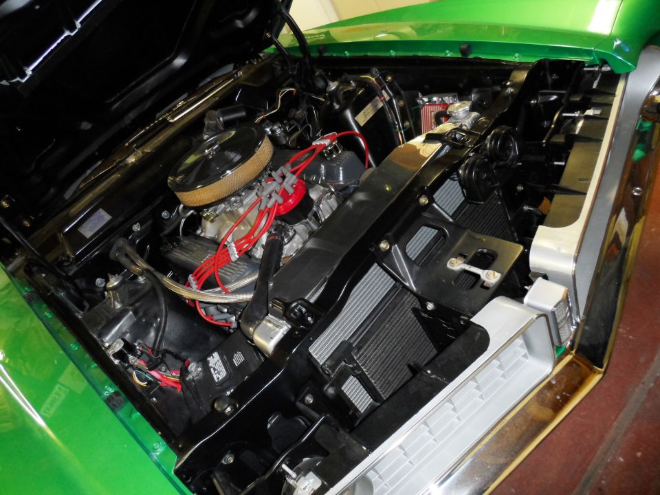 Green 1971 Ford Ranchero engine bay with chrome accents, V8 engine, and red spark plug wires