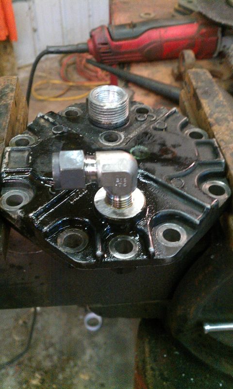 1995 Ford Bronco - Close-up of an air compressor head, showing its threaded ports and attached fittings.