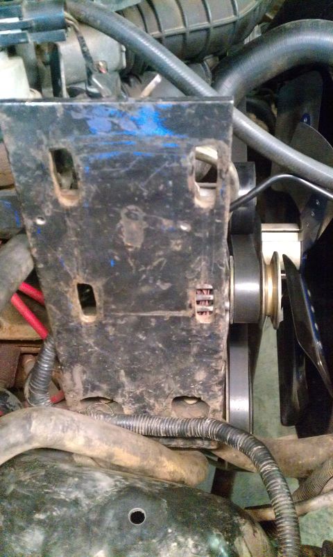 1995 Ford Bronco - Engine bay view showing a fan and mounting bracket with associated hoses and wiring.