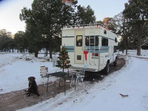1997 Dodge 3500 - A Lance camper is parked in a snowy area, decorated for Christmas with a tree and a dog nearby.