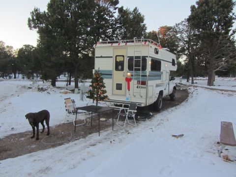1997 Dodge 3500 - A Lance camper truck is parked in a snowy area, decorated for Christmas with a tree and lights.
