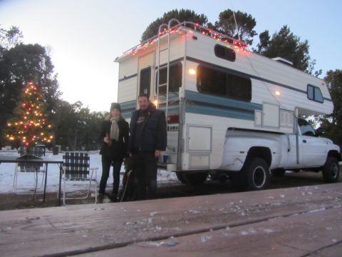 1997 Dodge 3500 - A 1997 Dodge 3500 pickup truck is outfitted with a camper and decorated with Christmas lights, parked near a decorated Christmas tree.
