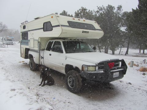 1997 Dodge 3500 - White 1997 Dodge 3500 pickup truck with a camper shell in a snowy landscape, with a dog and another RV in the background.
