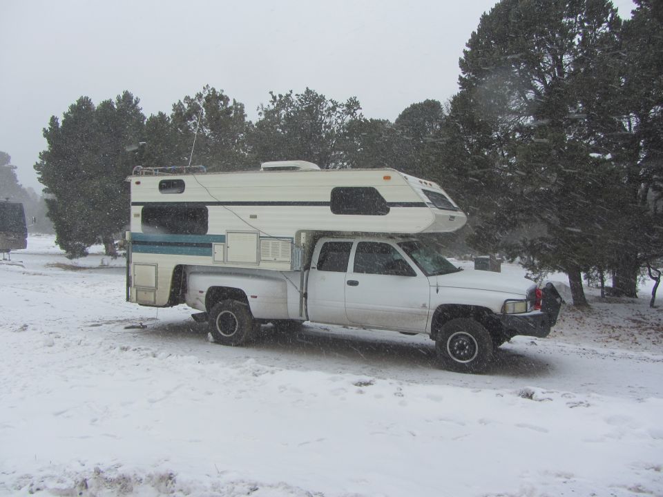 1997 Dodge 3500 pickup with camper shell parked in snow