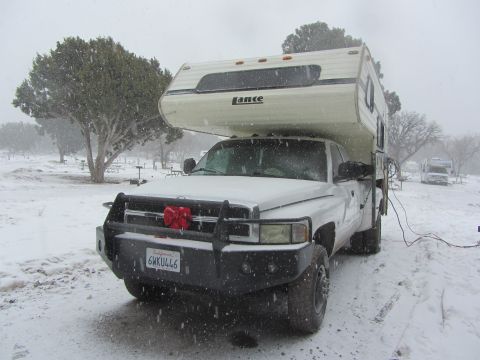 1997 Dodge 3500 - A Dodge 3500 pickup truck with a camper is parked in a snowy landscape, with another RV visible in the background.