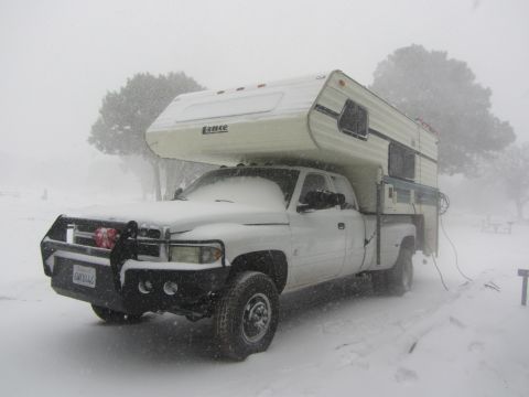 1997 Dodge 3500 - Dodge 3500 pickup truck with a camper shell in a snowy landscape.