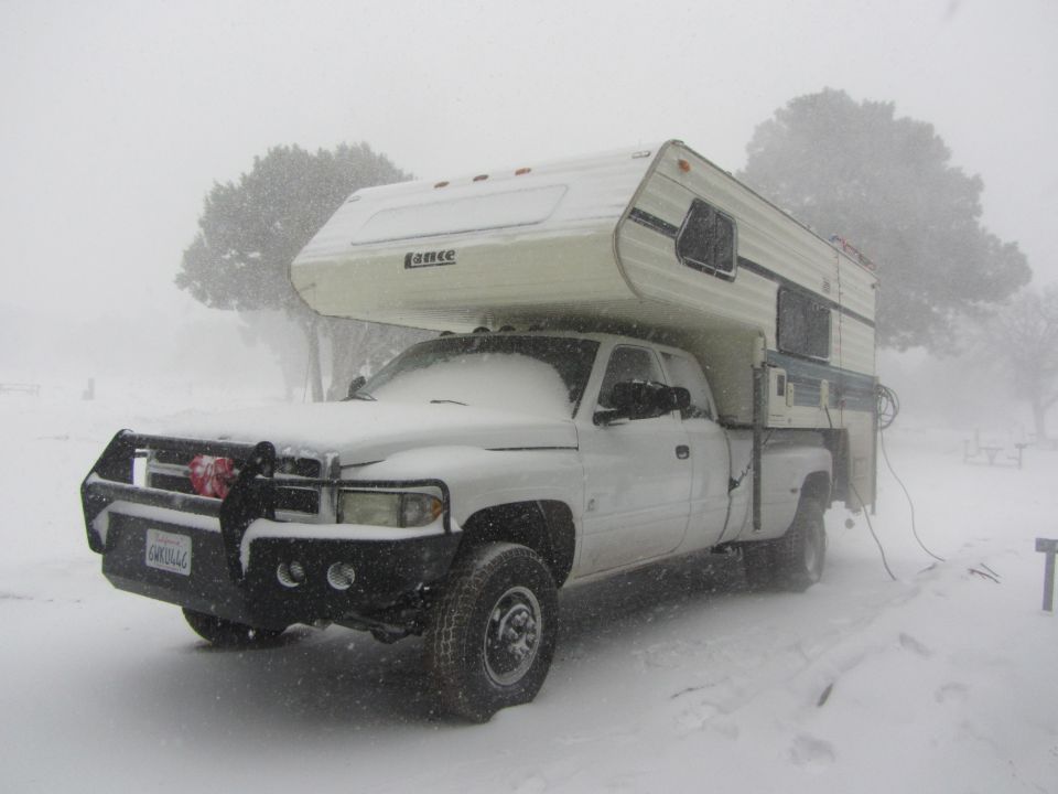 1997 Dodge 3500 pickup with Lance camper shell parked in snow