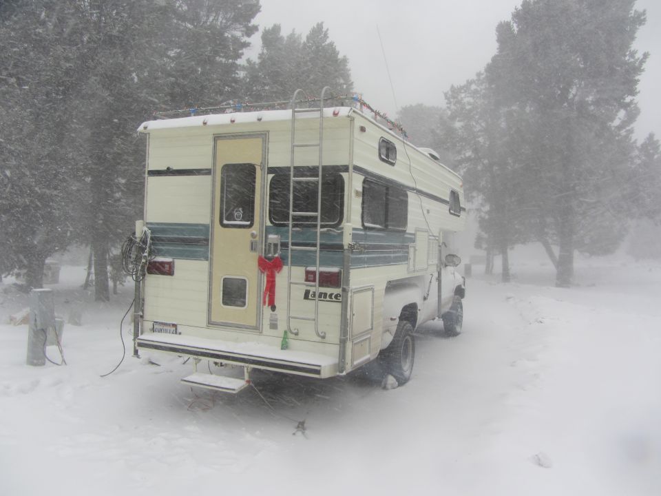 Lance camper on a white pickup truck in a snowstorm