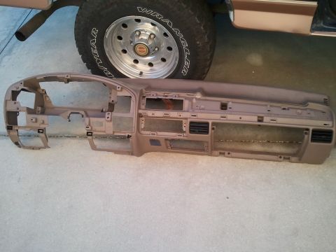 1994 Ford Bronco - A removed dashboard assembly is shown in front of a vehicle's tire and lower body panel.