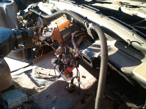 1994 Ford Bronco - Disassembled car dashboard reveals a complex network of wires and electronic components.