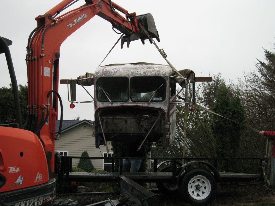Truck cab suspended by excavator, front view