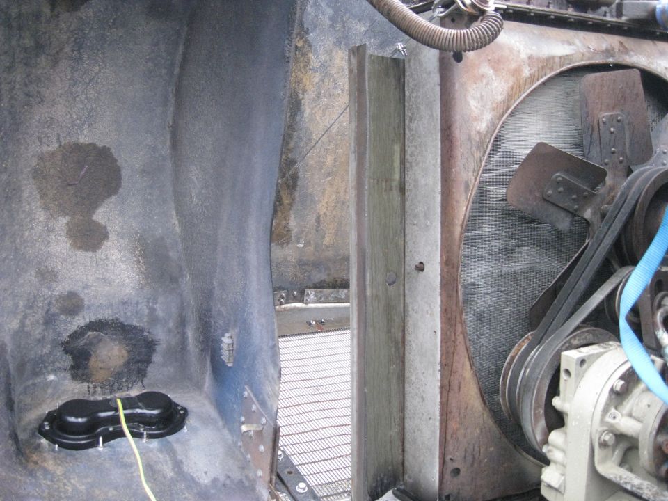 Close-up of a truck's engine bay showing the radiator, fan, belts, and part of the engine block