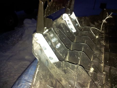 1990 Chevrolet Suburban - Close-up of a modified snowmobile track component, indicating custom modifications with added metal bracing.