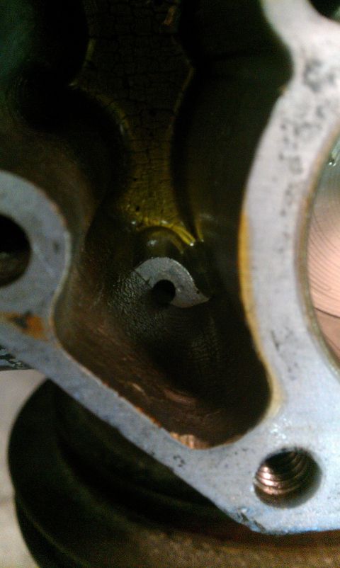 1995 Ford Bronco - Detail of an engine component, showing internal passages and a small circular opening with a notch.
