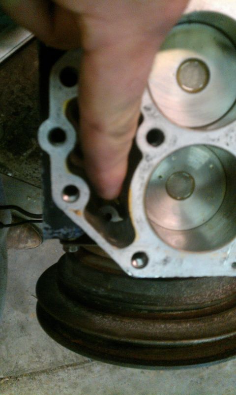 1995 Ford Bronco - Engine cylinder head detail, showing internal components and a finger pointing to a port.