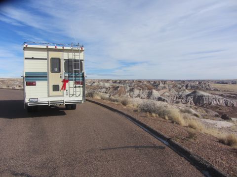 1997 Dodge 3500 - An RV is parked on the side of a road, with a vast, arid landscape stretching out in the background under a partly cloudy sky.