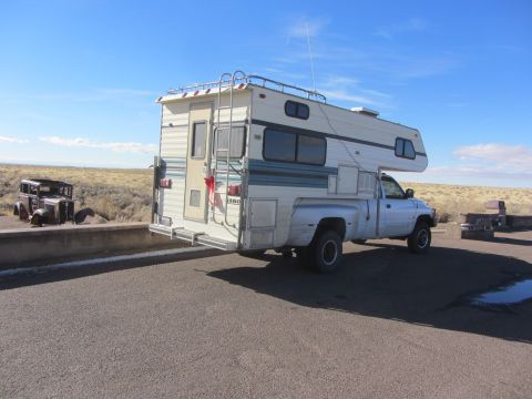 1997 Dodge 3500 - A 1994 Dodge Ram 3500 camper van is parked next to a vintage automobile under a clear blue sky.
