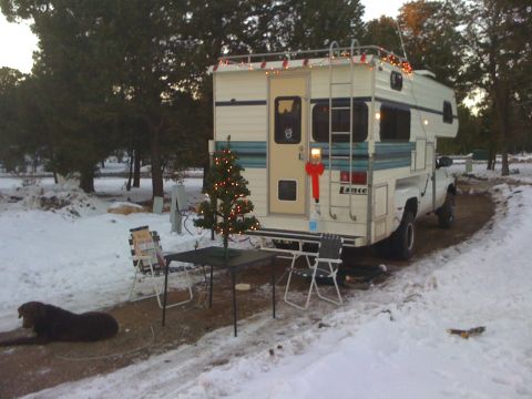 1997 Dodge 3500 - A camper truck decorated for Christmas sits in a snowy landscape. The camper unit has 'Lance' branding visible.