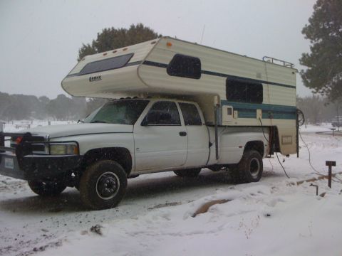 1997 Dodge 3500 - A white 1997 Dodge 3500 pickup truck equipped with a camper shell is parked in a snowy landscape.