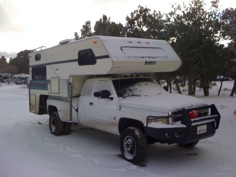 1997 Dodge 3500 - This 1997 Dodge 3500 pickup truck is equipped with a camper shell and is parked in a snowy landscape.