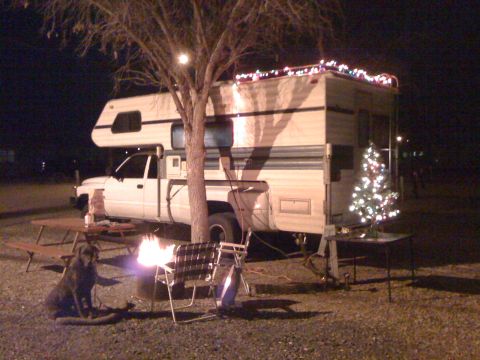 1997 Dodge 3500 - Dodge pickup truck with camper shell and Christmas lights at a campsite.