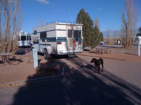 1997 Dodge 3500 - 1997 Dodge 3500 pickup truck with camper shell at a campsite, with a dog and another RV in the background.