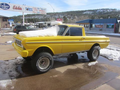 1964 Ford Ranchero - A bright yellow 1964 Ford Ranchero pickup truck sits outside in the snow, a lifted suspension and BFGoodrich tires.