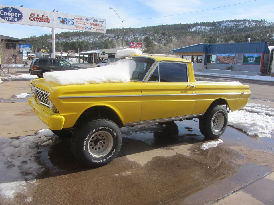 Yellow 1964 Ford Ranchero with lifted suspension and snow on the hood