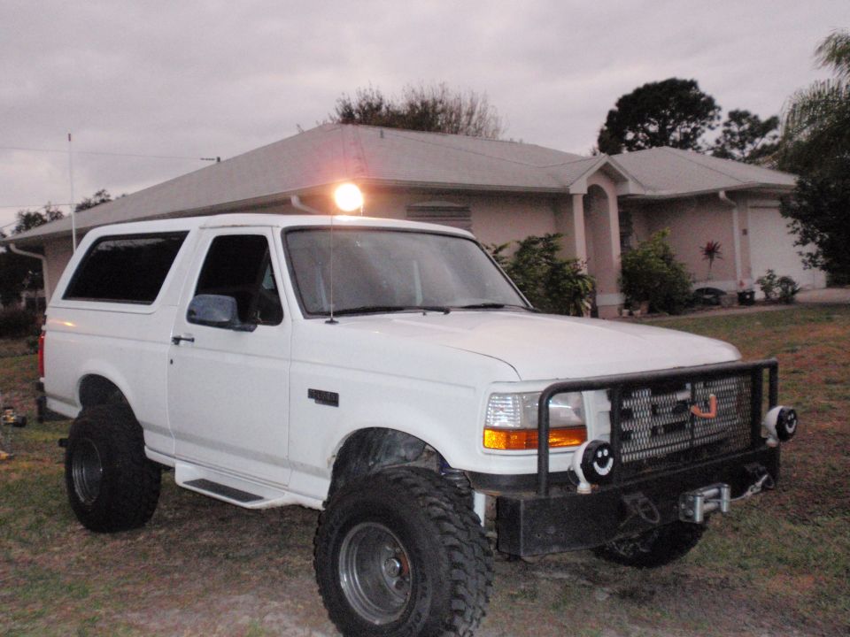 1995 Ford Bronco, white, with bull bar, off-road tires, and a light on top