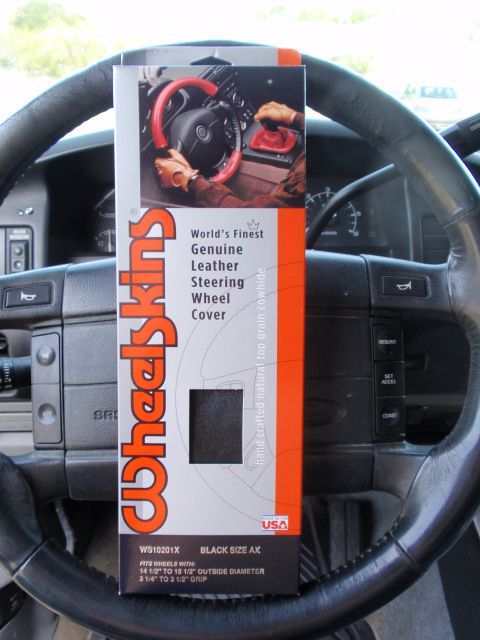 1995 Ford Bronco - Packaging for a Wheelskins steering wheel cover is displayed on the steering wheel of a vehicle.
