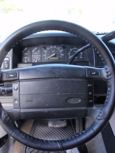 1995 Ford Bronco - Close-up of the dashboard and steering wheel of a truck, with visible gauges and controls.