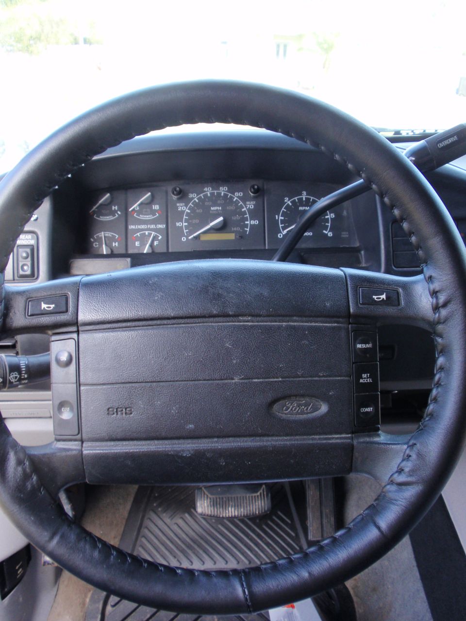 Dashboard and steering wheel of a truck, showing gauges and Ford logo on steering wheel