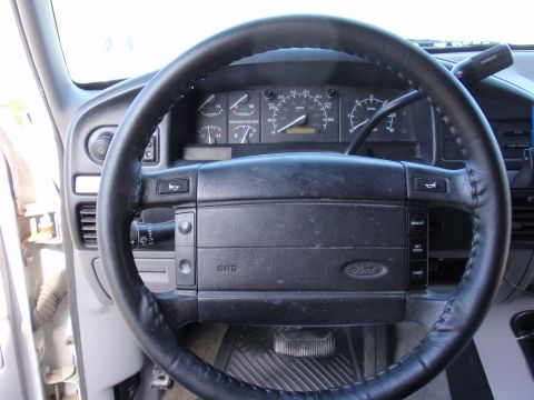 1995 Ford Bronco - Ford leather-wrapped steering wheel with SRS airbag and instrument cluster including speedometer and gauges, interior dashboard view.