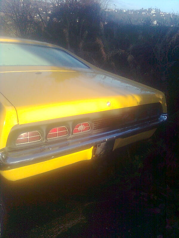 Yellow 1970 Ford Ranchero rear view, showing taillights and chrome bumper