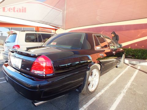 2003 Ford Crown Victoria - Customized black sedan viewed from the rear three-quarter while parked at a detailer.
