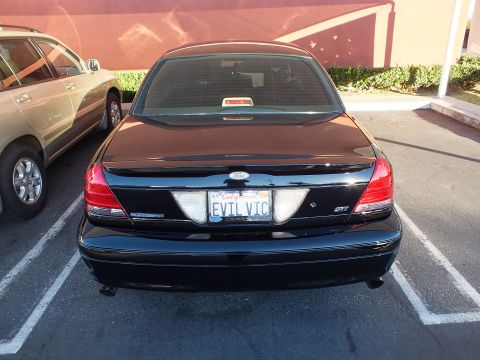 2003 Ford Crown Victoria - Straight rear shot of a black Crown Victoria, EVIL VIC plate centered between taillights.